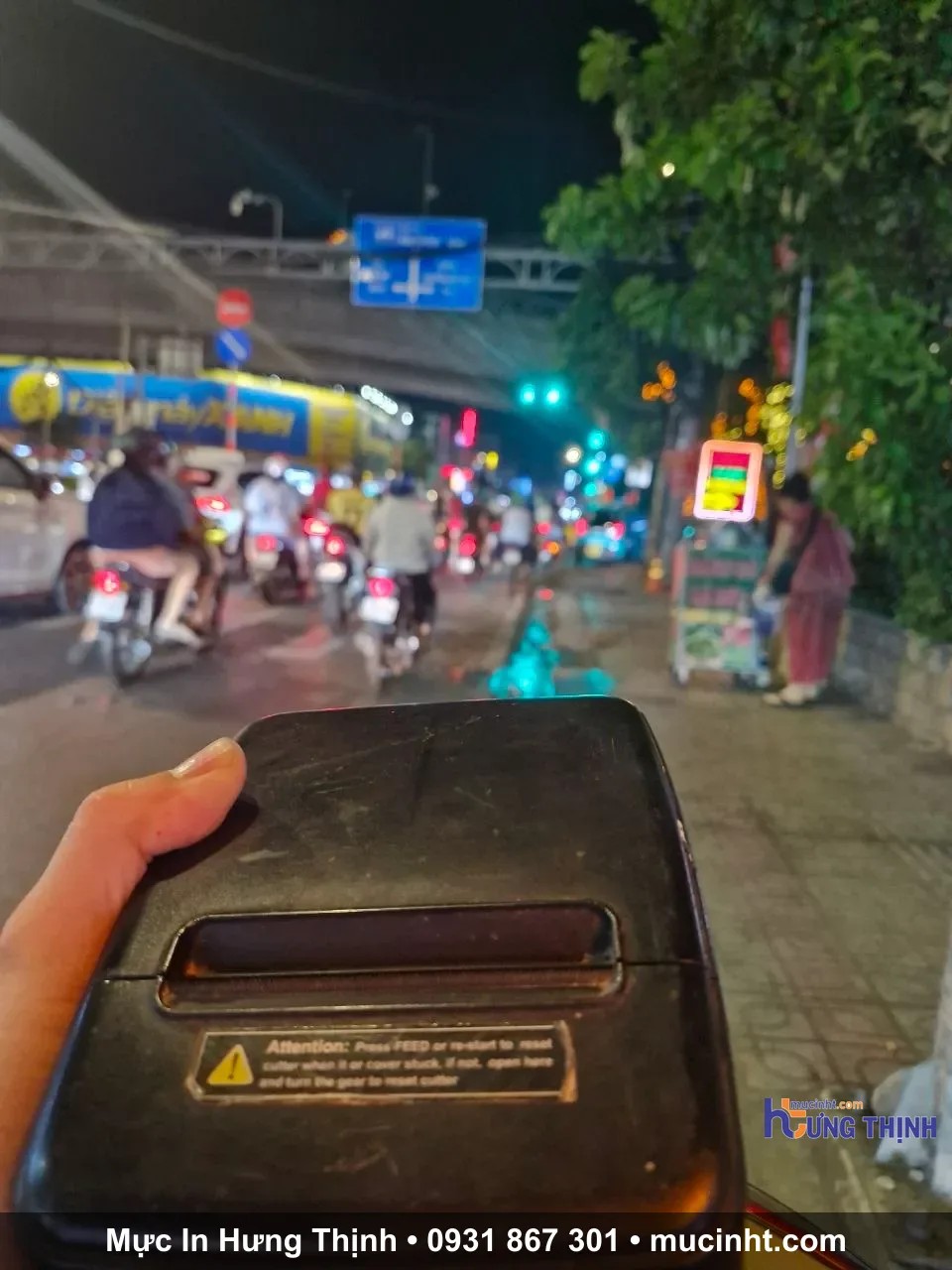 Kỹ thuật viên xử lý máy in nhiệt cho quán vào buổi tối tại TP.HCM